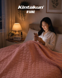 Seorang wanita menggunakan handphone di dalam kamar sambil menggunakan Ultrasonic Blanket Dual Tone